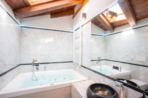 Falegnami Boutique Suites - BolognaRooms في بولونيا: حمام مع حوض ومغسلة