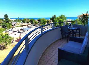 balcón con mesa, sillas y vistas al océano en VistaMare Bluemar - The Art of the Sea - 105mq en Cattolica