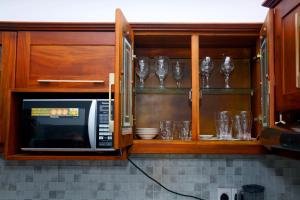 a kitchen with a microwave and some glasses at Lotus View Apartment Colombo in Colombo