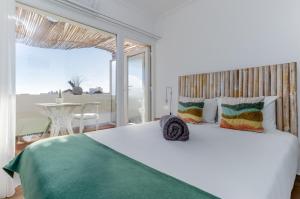 Un dormitorio con una gran cama blanca y una mesa en Villa Center - Alojamento Local en Grândola
