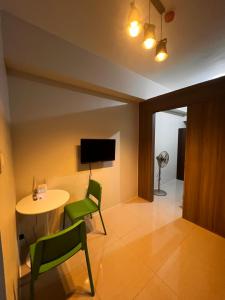 a living room with a table and chairs and a television at Elresa Elegant at Field Residences Condominium Hotel in Manila