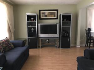 sala de estar con sofá y TV de pantalla plana en Private Rooms Male Accommodation Close to NAIT Kingsway Mall Downtown en Edmonton