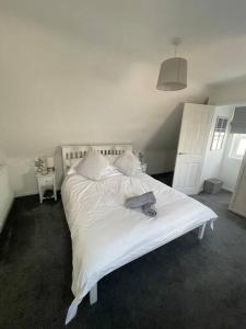 a bedroom with a white bed with a book on it at Hyfrydol Bach in Maesteg