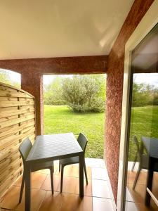 una mesa y sillas en un patio con ventana en Joli studio Arles avec terrasse et verdure, en Arles