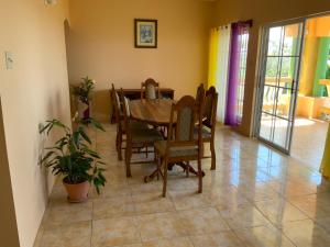 una sala da pranzo con tavolo e sedie di Poinciana House a Montego Bay