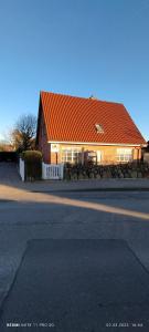 a house with an orange roof next to a street at Privates Domizil auf Sylt in Strandnähe in Westerland (Sylt)