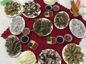 a table with plates of oysters and other foods at Bảo Ngọc Cô Tô hotel in Dao Co To +23 photos