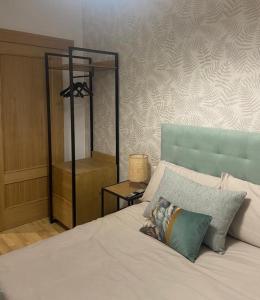 a bedroom with a white bed with a blue headboard at Apartamento casco histórico in Zamora
