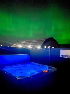 einen Whirlpool in einem Zimmer mit grünem Himmel in der Unterkunft 2 Sinclair bay lodges in Keiss
