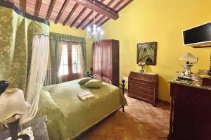 a bedroom with a green bed and a dresser at Agriturismo Rosa dei Venti in Pomarance