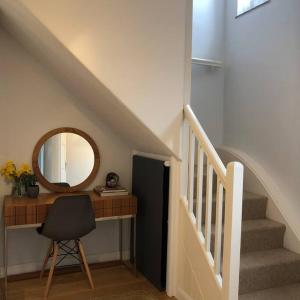 een trap met een bureau, een spiegel en een stoel bij Beautiful Totnes home with parking in Totnes