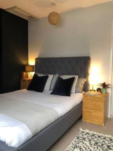 een slaapkamer met een groot bed met 2 kussens bij Beautiful Totnes home with parking in Totnes
