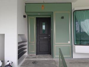 a front door of a house with a green wall at I Do Farmstay in Bukit Mertajam