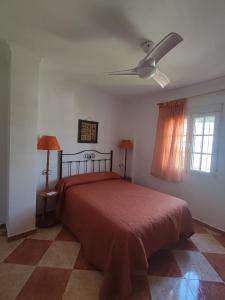 1 dormitorio con 1 cama y ventilador de techo en CASA RURAL FERRETE, en Cañete la Real