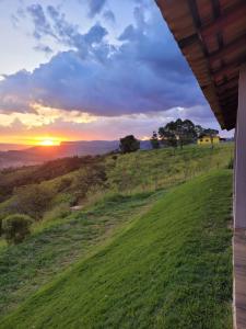 a view of the sunset from the porch of a house at Colina da Canastra Pousada in São Roque de Minas