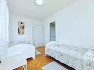 Habitación blanca con 2 camas y espejo. en Apartments Doris, en Split