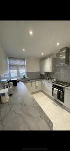 een keuken met witte kasten en een marmeren vloer bij 2 bedroom apartment in Londen