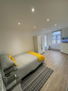 een slaapkamer met een bed met een gele deken bij 2 bedroom apartment in Londen