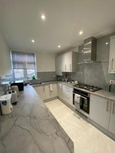 een grote keuken met witte kasten en een fornuis bij 2 bedroom apartment in Londen