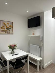 ein weißer Tisch mit einer Vase Blumen drauf in der Unterkunft 2 bedroom apartment in London