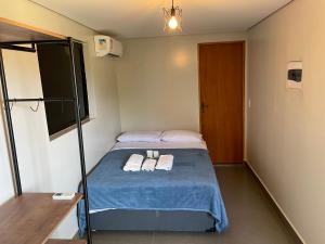 a small room with a bed with two towels on it at Estância EK in Franca