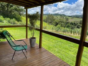 a green chair sitting on a wooden deck with a view at Estância EK in Franca