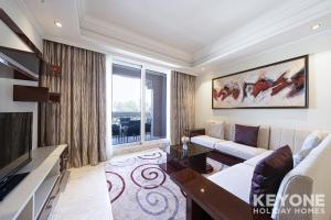 een woonkamer met een bank en een tv bij Two Bedroom Sea View Apt with Private Beach Access in Dubai