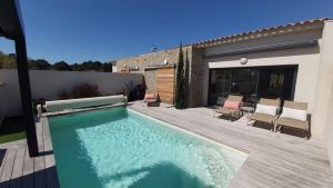 a swimming pool in a backyard with a wooden deck at Villa HOME HOLIDAY à Cala Rossa in Lecci
