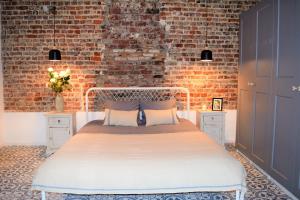 1 dormitorio con 1 cama con pared de ladrillo en Home Sweet Home Brussels center, en Bruselas