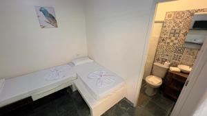 a small bathroom with a toilet and a sink at Pousada Nova Ascalom in Ubatuba