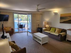 ein Wohnzimmer mit einem Sofa und einem Tisch in der Unterkunft Water View. 1bedroom Sleeps 2. WI-FI, Wash Machine in South Stradbroke