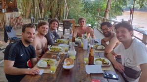 a group of men sitting around a table eating food at Majacho`s House in Puerto Maldonado