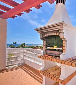 Una chimenea en un balcón con el océano al fondo. en Villa Melanésia by Algarve Vacation, en Guia