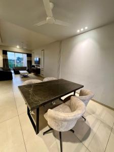 a dining room with a black table and chairs at CAPETOWN VILLAS (MOUNTAIN VIEW) in Igatpuri