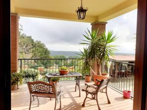 Manziana的住宿－La Casa Più Sù，设有一个配有桌椅并享有美景的阳台。