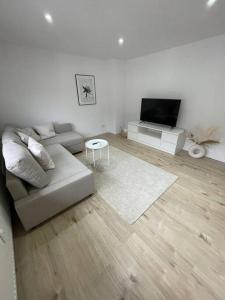 sala de estar con sofá y TV de pantalla plana en Casa Bergstraße 2, en Bensheim
