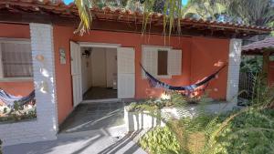 an orange house with a string of flags on it at Pousada Nova Ascalom in Ubatuba