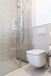 a white bathroom with a shower and a toilet at Boardinghouse Plattling in Plattling