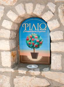 a sign for a potted plant in a stone wall at Filio rooms in Kythira