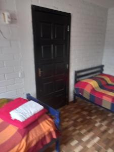 Pokój z dwoma łóżkami i czarnymi drzwiami w obiekcie Nino's w mieście Niterói