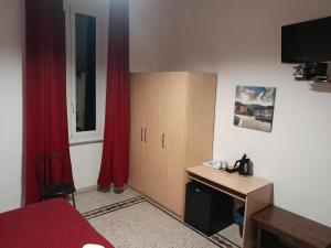 una camera con letto, scrivania e armadio di Nautilus Hotel a La Spezia