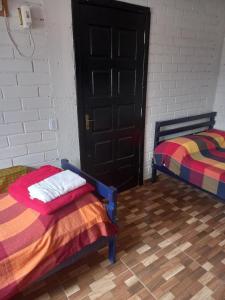 a room with two beds and a black door at Nino's in Niterói