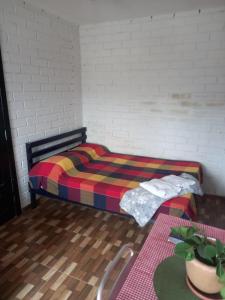 1 dormitorio con 1 cama con una manta colorida en Nino's en Niterói