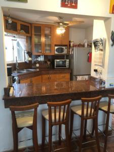 a kitchen with a counter and four bar stools at Casa Mi Tesoro Vacation Rooms in Playa del Carmen