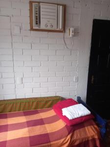 a room with a bed with a white brick wall at Nino's in Niterói