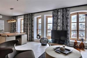 a living room with a tv and some windows at Les Immeubles Charlevoix - Le 1172 in Quebec City