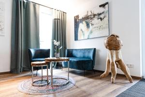 a living room with two blue chairs and a table at Boardinghouse Plattling in Plattling