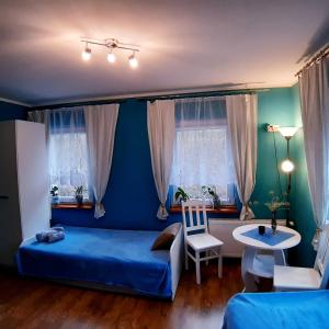 sypialnia z niebieskimi ścianami, łóżkiem i stołem w obiekcie WILLA Jugowice w mieście Jugowice