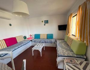 a living room with two beds and a tv at Olhos do mar 209 grande terraço vista mar in Olhos de Água