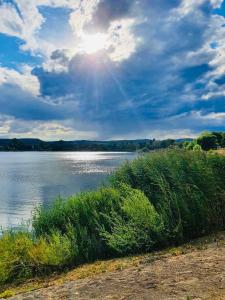 a view of a body of water with the sun at Tóparti Kuckó in Mályi